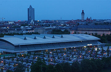 QUARTERBACK Immobilien ARENA am Abend mit der Stadt Leipzig im Hintergrund.