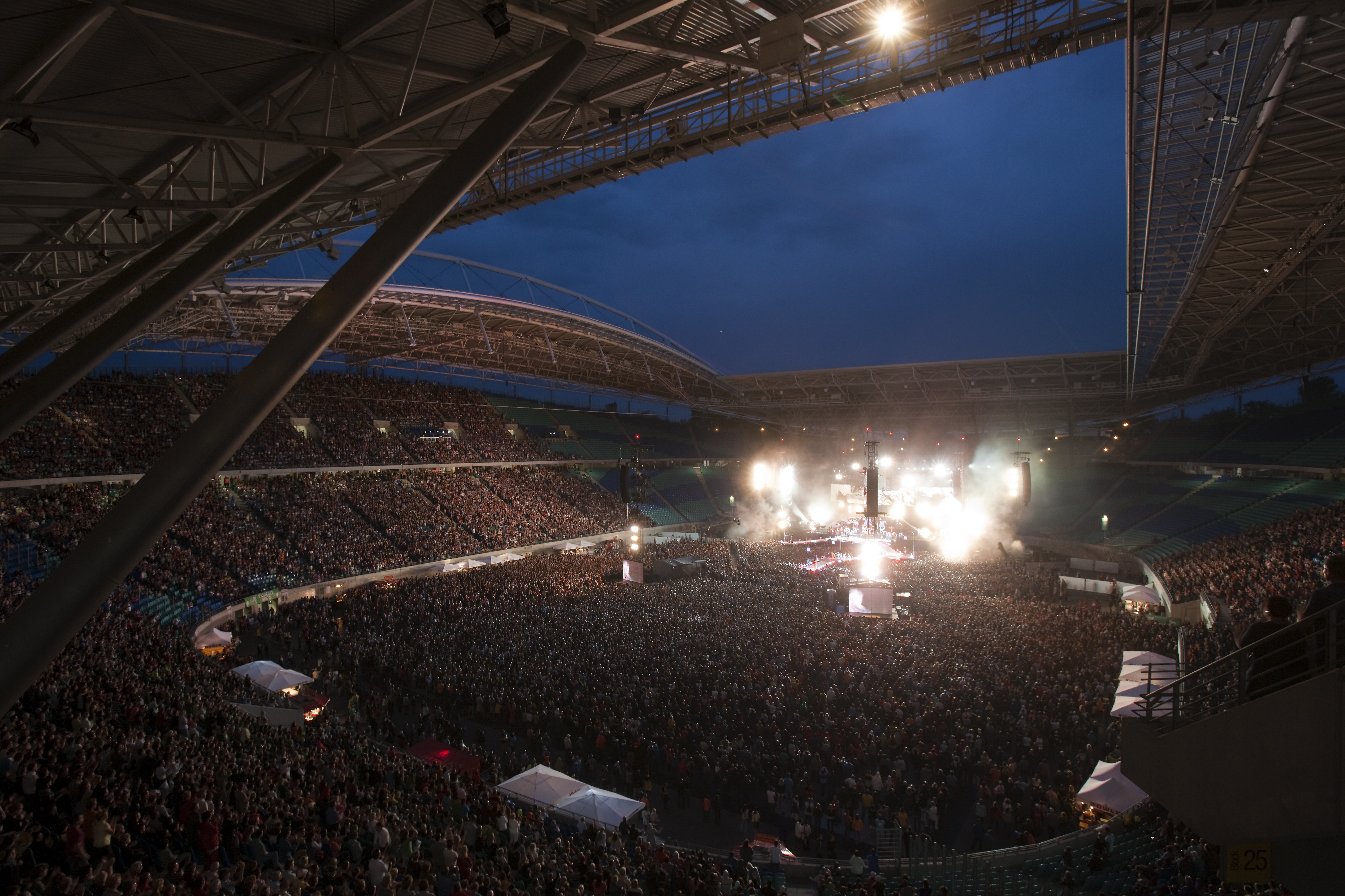 Blick in den Innenraum der Red Bull Arena mit zahlreichen Menschen die ein Stadionkonzert verfolgen.